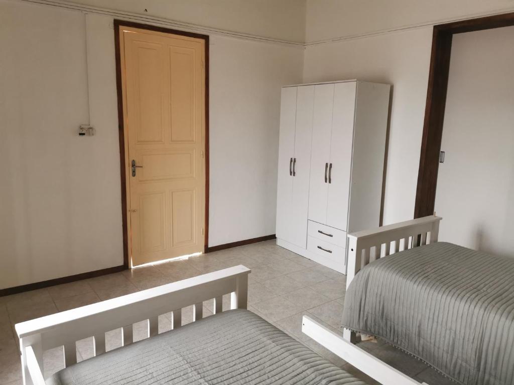 ein Schlafzimmer mit zwei Betten, einem Kleiderschrank und einer Tür in der Unterkunft Lo de Mary in Rocha