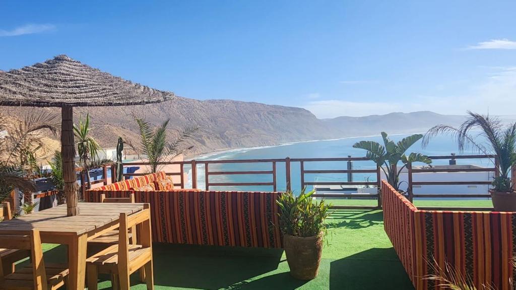 un patio con tavolo e vista sull'oceano di Padova Surf House a Imsouane