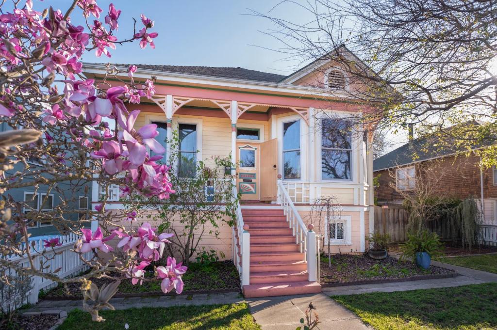 瓦列霍Historic Queen Anne with private backyard oasis!的前面有粉红色花的房子