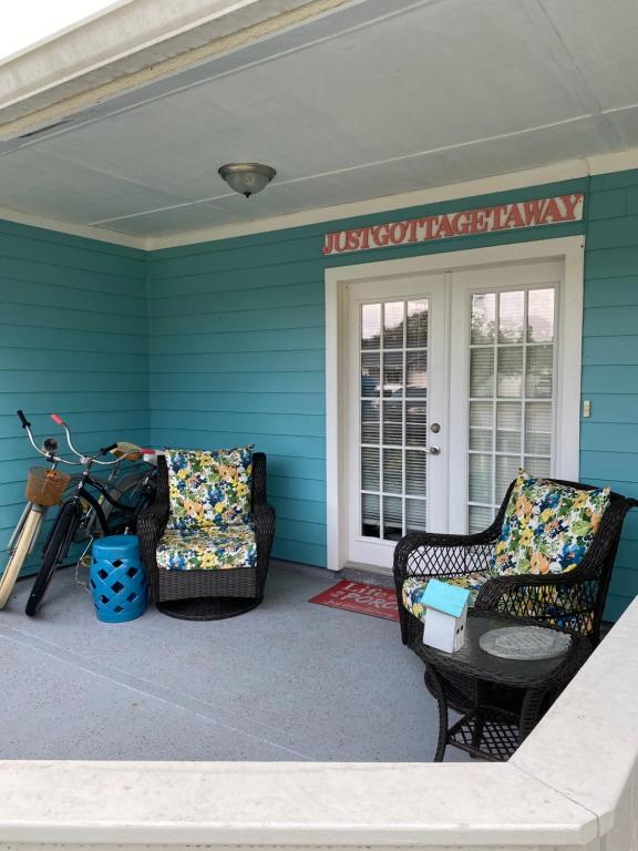a front porch with two chairs and a table at Just Gotta Getaway in Port Orange