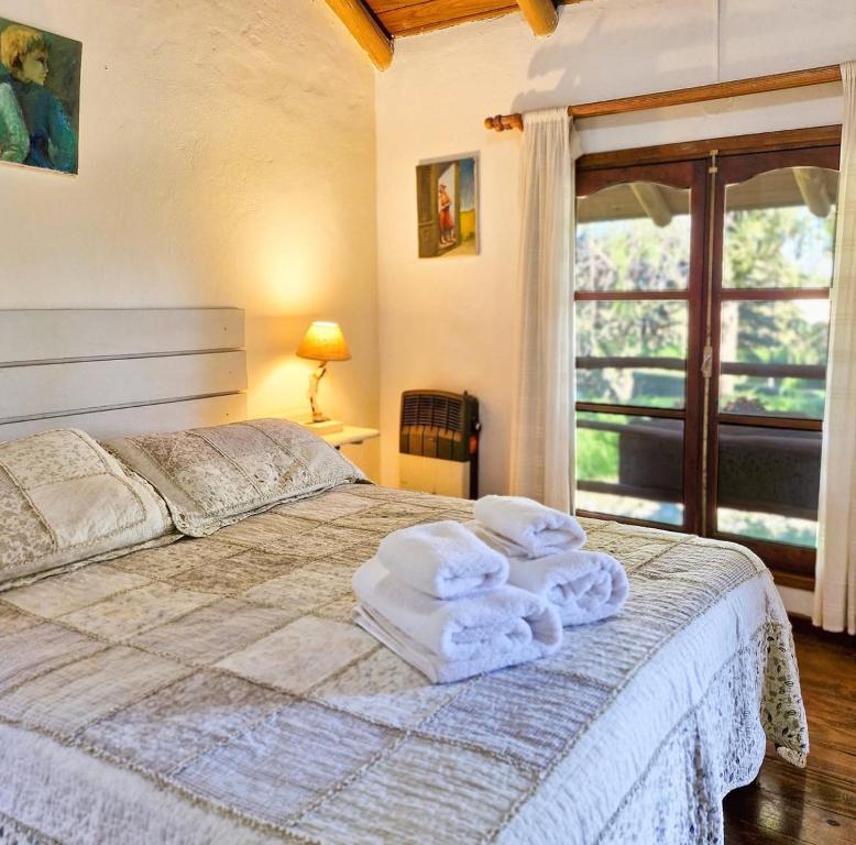 ein Schlafzimmer mit einem Bett mit Handtüchern darauf in der Unterkunft Posada La Lucía in Villa General Belgrano