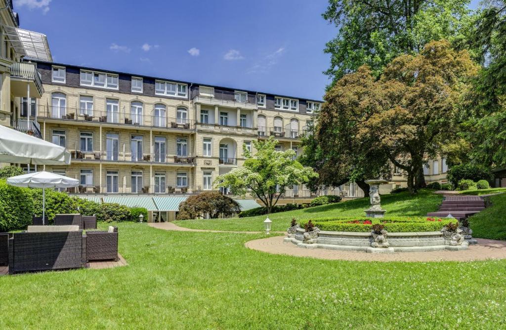 park przed dużym budynkiem w obiekcie Hotel am Sophienpark w Baden-Baden