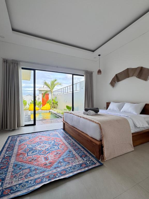 a bedroom with a bed and a large window at Aloka Villa -Stylish 2 bedroom villa in the heart of Seseh in Munggu