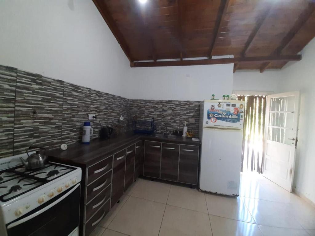 una cucina con fornelli e frigorifero bianco di Chalet en Mogotes a Mar del Plata