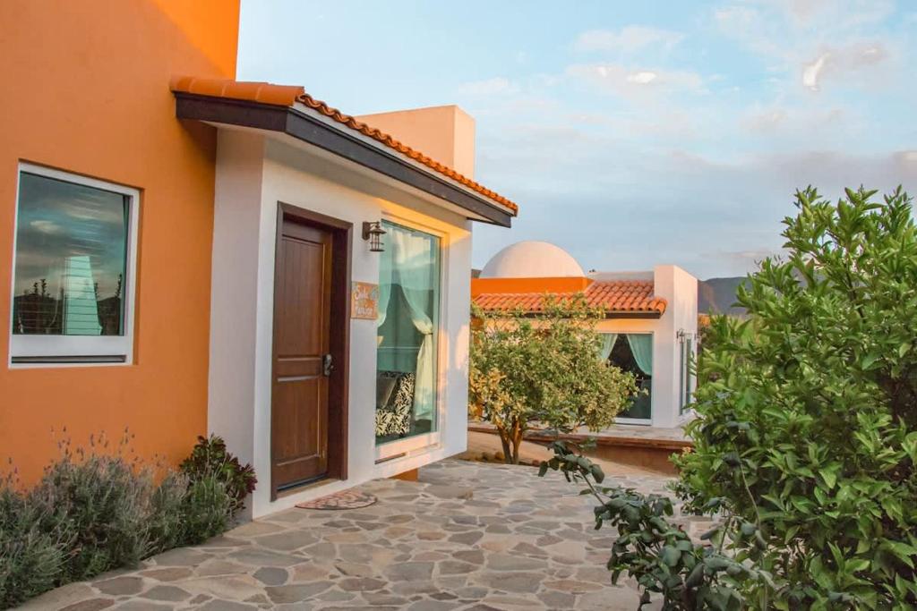 une maison aux murs orange et avec une terrasse dans l'établissement Suite Paradise Hospedaje Romantico en Valle de Gpe, à San Pablo