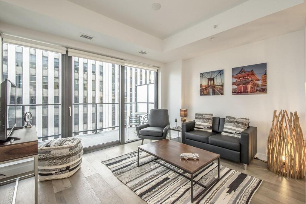 ein Wohnzimmer mit Sofa und Tisch in der Unterkunft Cozy 2BR Apt with Gym and Cinema near Pier 21 in Halifax