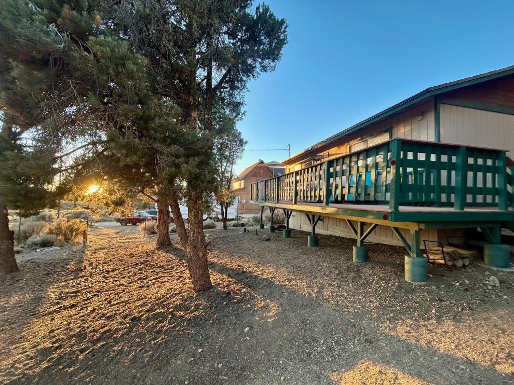 a building with a porch next to a tree at Peaceful Big Bear Cabin in Baldwin Lake