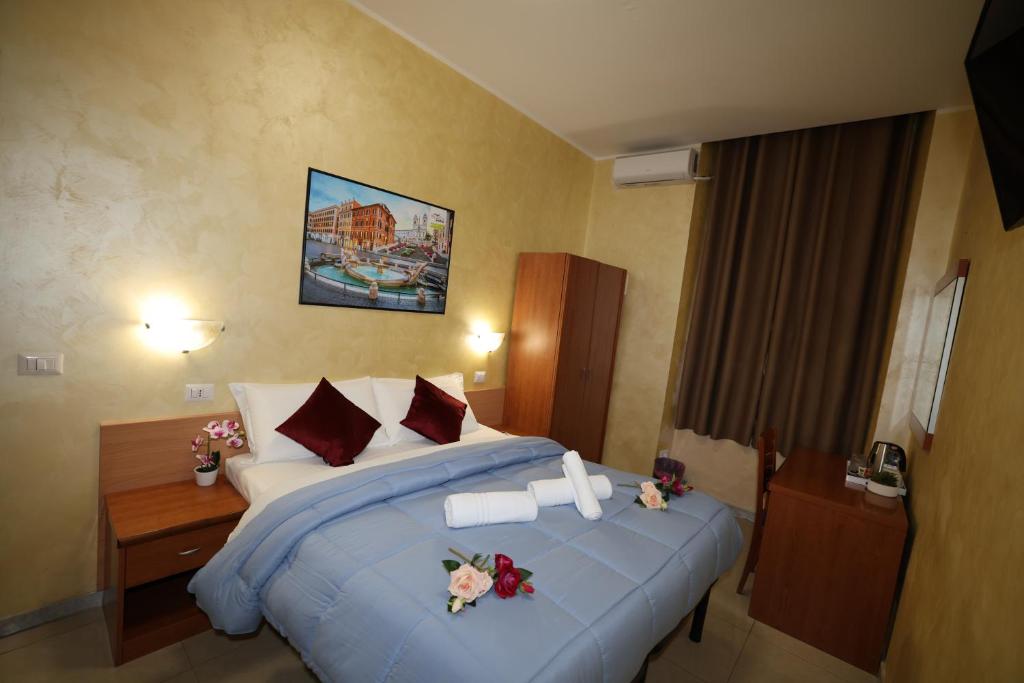 ein Hotelzimmer mit einem großen Bett und einem Schreibtisch in der Unterkunft Dreamland Guesthouse in Rom