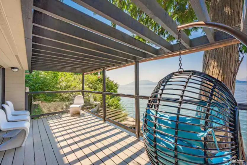 een prieel met schommel op een terras bij SALT COTTAGE Waterfront Guest House with Superb Views in West Vancouver