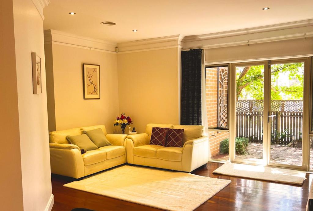 - un salon avec un canapé jaune et une fenêtre dans l'établissement Inner North Elegance Premier Turner Living 2 Bed, 2 Bath Townhome, à Turner