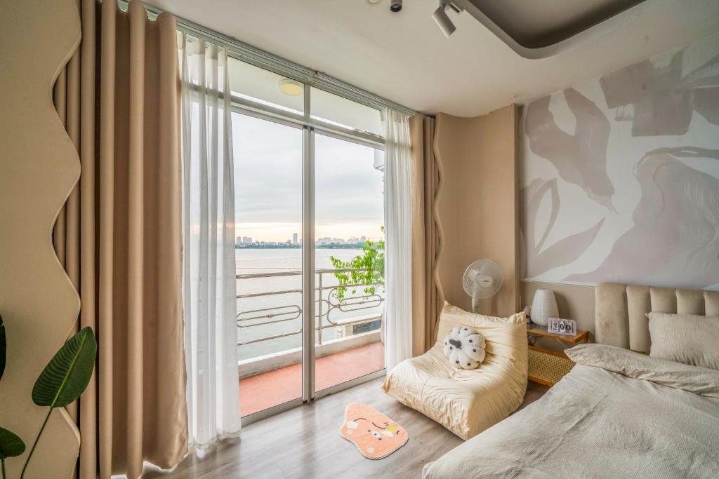 a bedroom with a bed and a large window at Aimee House Vũ Miên in Hanoi