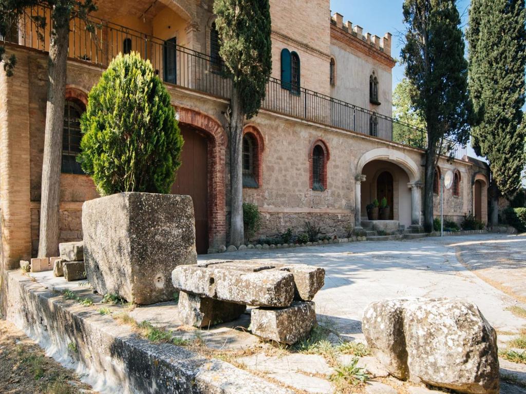 ein Gebäude mit Steinbänken vor einer Straße in der Unterkunft Cottage in Castellnou with Forest Trails in Castellnou de Bages