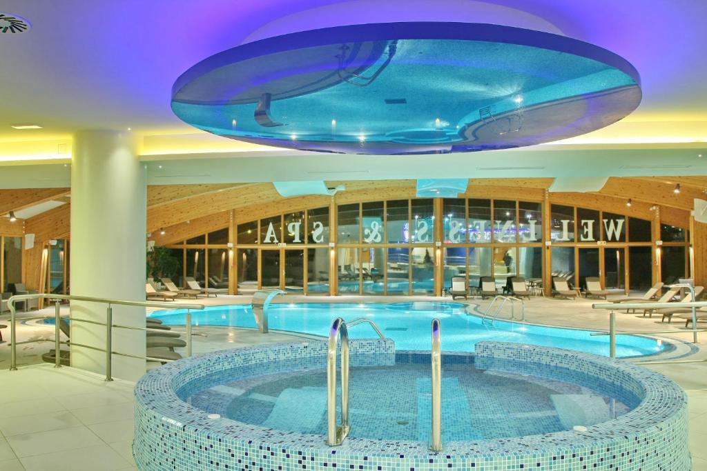 a large swimming pool in a building with a blue ceiling at Hotel Olimp in Zlatibor