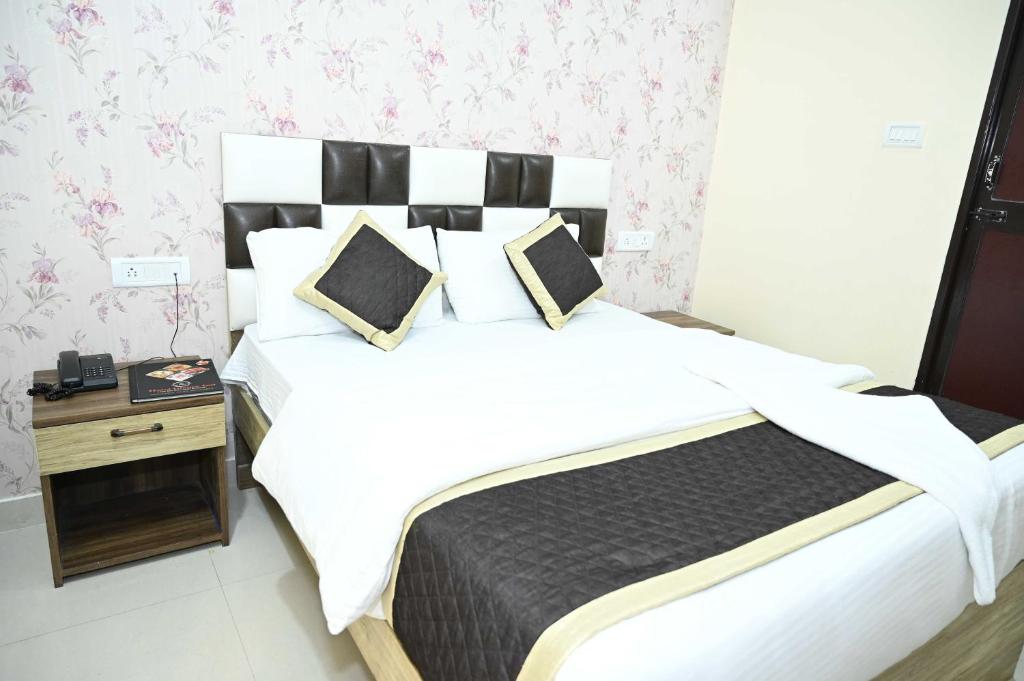 a bedroom with a large bed and a night stand at Hotel O Glance Inn in Patna