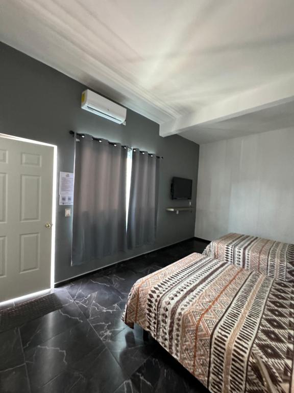 a bedroom with a bed and a door with a window at Hotel Real Mixteca in Huajuapan de León