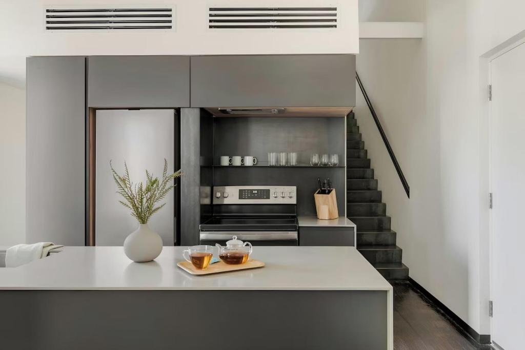 a kitchen with a white counter and a staircase at Ida Phoenix in Phoenix