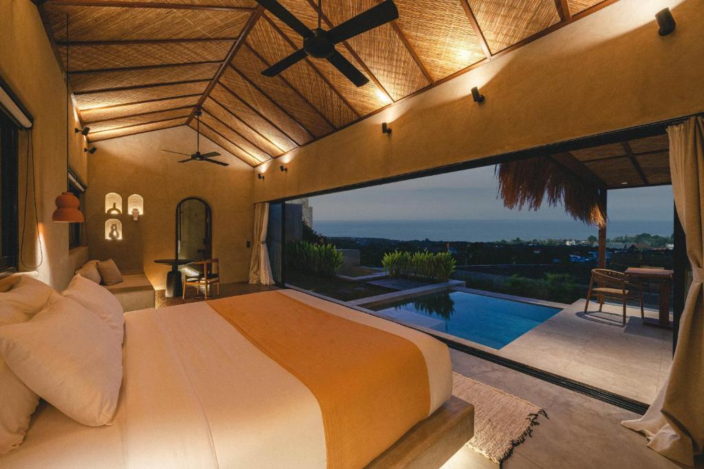 ein Schlafzimmer mit einem großen Bett und einem Pool in der Unterkunft SIVANA, Hotel Boutique with ocean or garden views - Adults only in Uluwatu