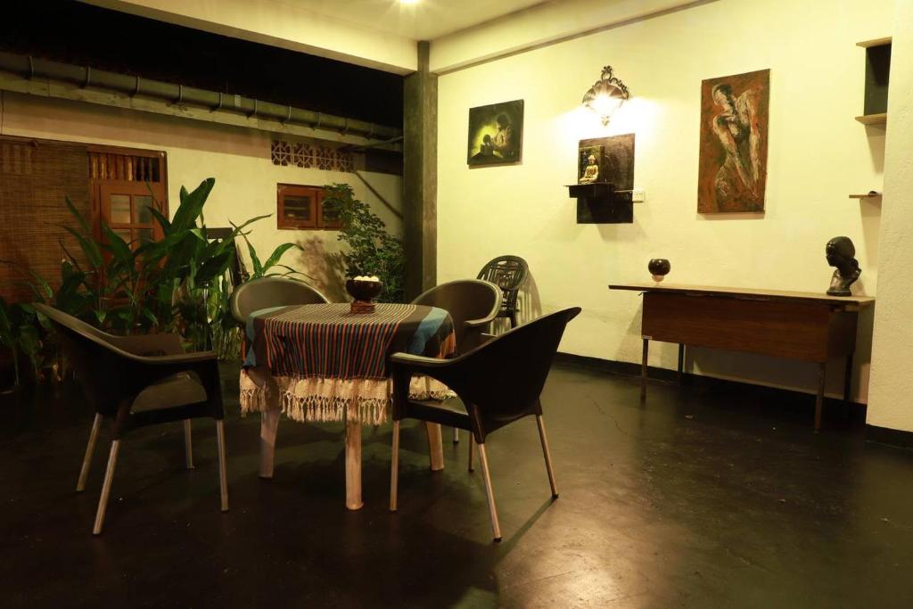Un comedor con una mesa y sillas y un piano. en Karu's place, en Hikkaduwa
