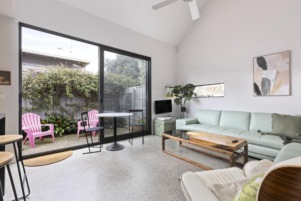 ein Wohnzimmer mit Sofa und Tisch in der Unterkunft Spacious 1-Bed Townhouse in Norlane in Norlane