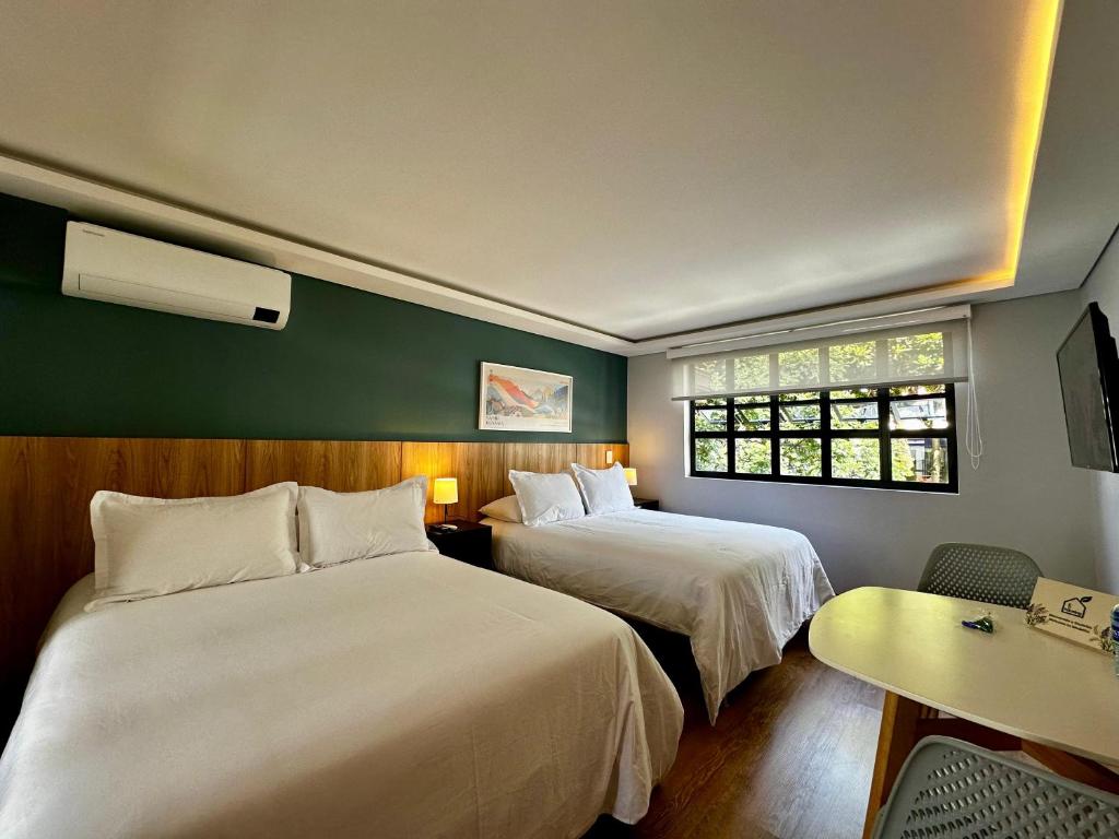 a hotel room with two beds and a table at Ecohousing in Medellín