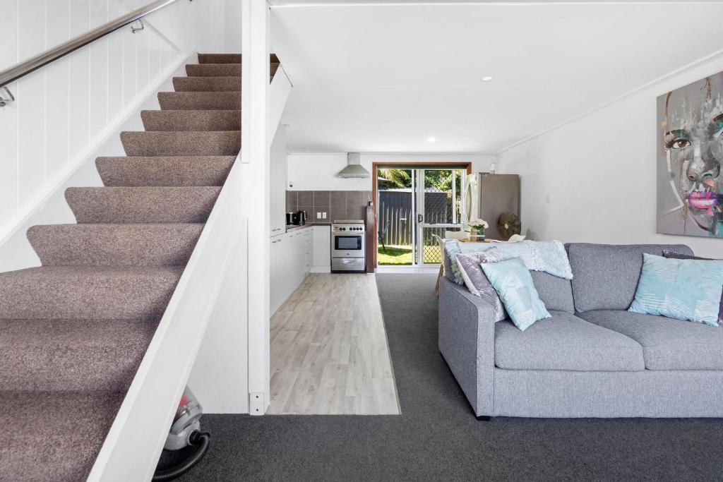 Una sala de estar con una escalera y un sofá. en Self-contained Studio close to Kensington Park, en Whangarei