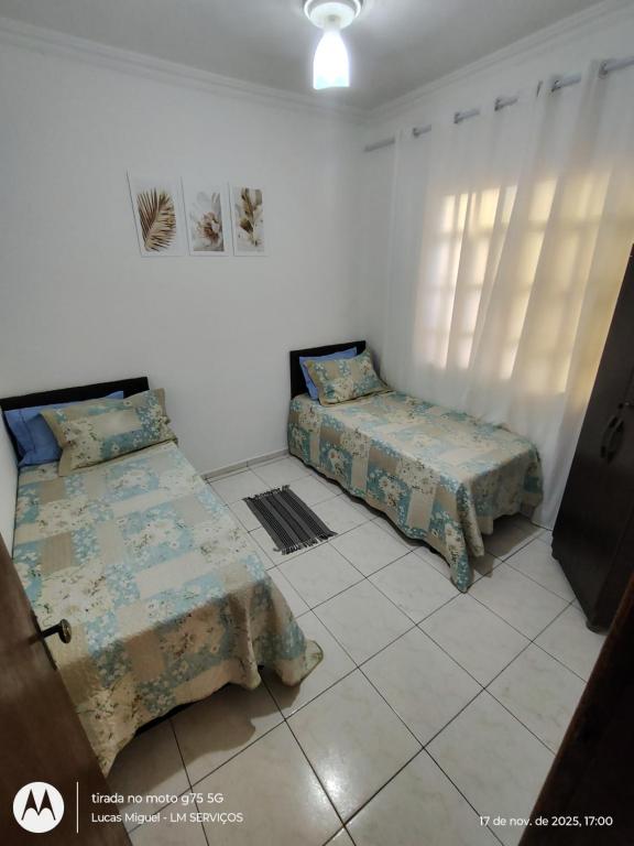a bedroom with two beds in a room at LM Home 1 - casa com 2 quartos e ar condicionado in Governador Valadares