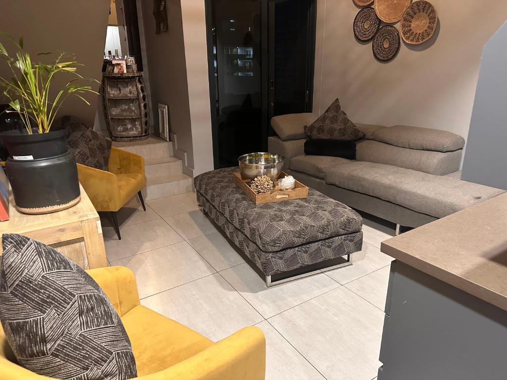 ein Wohnzimmer mit Sofas, Stühlen und einem Tisch in der Unterkunft The Onyx Black in Durban