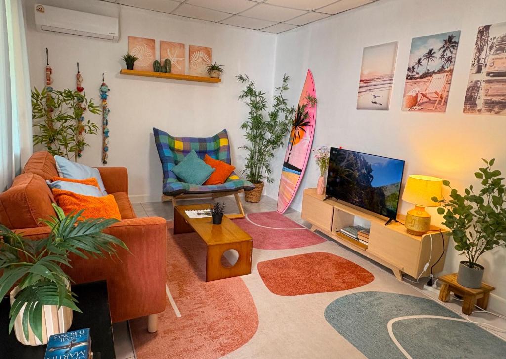 ein Wohnzimmer mit Möbeln und einem Flachbild-TV in der Unterkunft Bamboo Beach House @ Phang Nga in Thai Muang