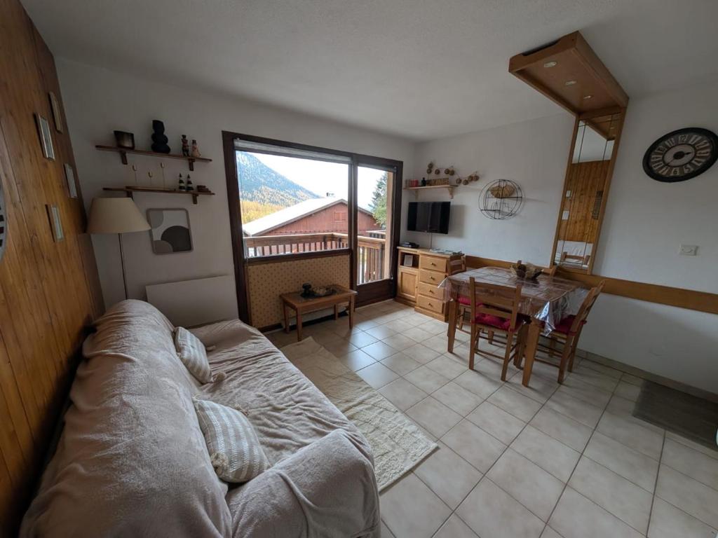 a living room with a bed and a dining room table at Confort pour 4, proche pistes, garage, balcon sud - FR-1-445-231 in Montgenèvre