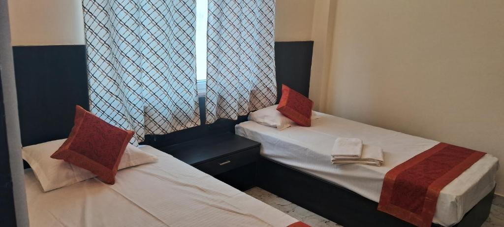 a small room with two beds and a window at Hotel Pratyaksh Darshan in Varanasi