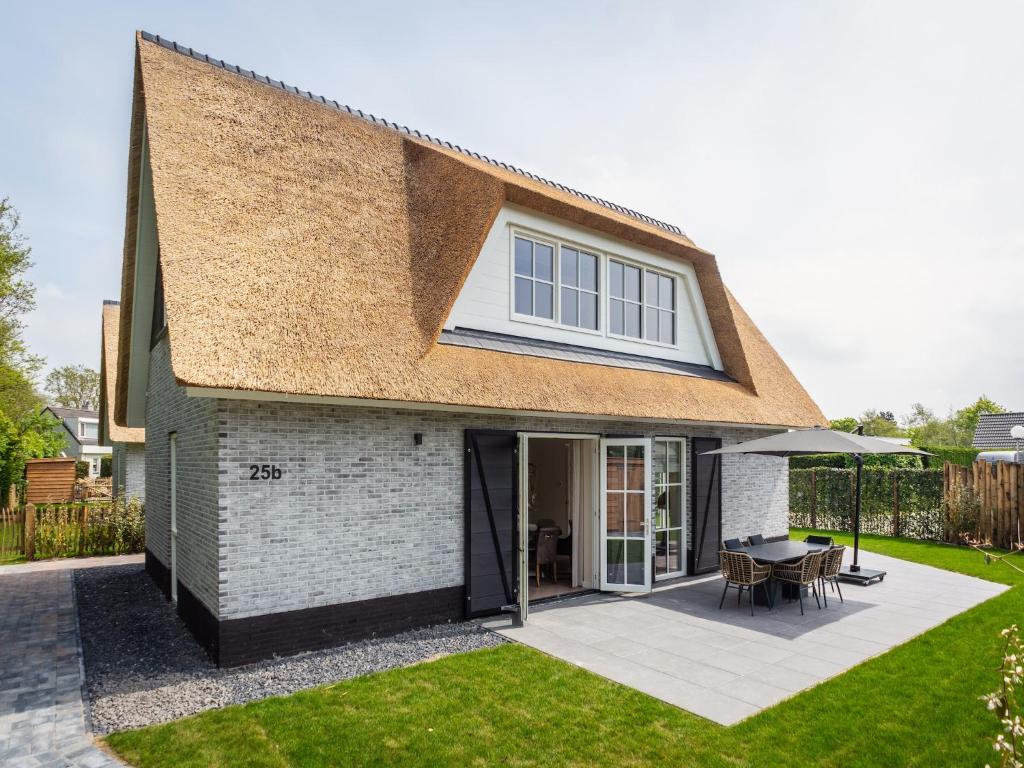 ein Haus mit einer Terrasse und einem Tisch im Hof in der Unterkunft Pretty Holiday Home in De Koog Texel with Garden in Westermient