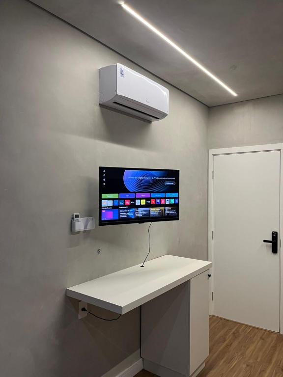 a room with a counter with a tv on the wall at Carneiro Hotel in Itatiba