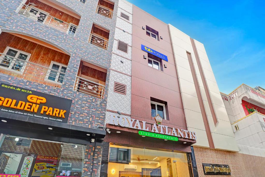 a pink building with a sign in front of it at Hotel RA Apartment in Chennai
