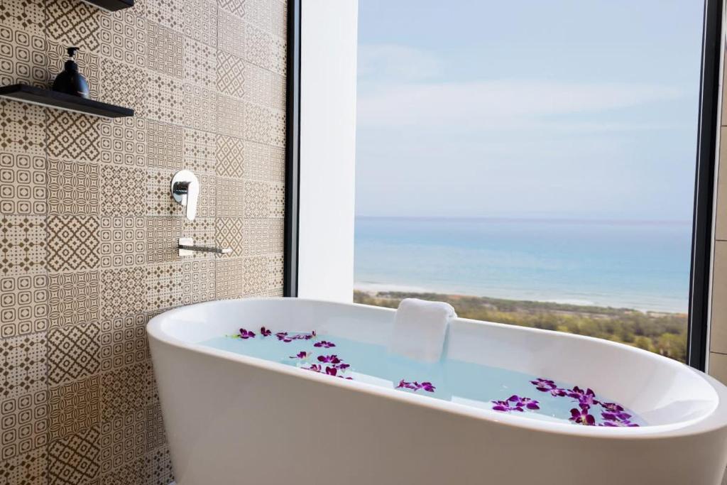 eine weiße Badewanne in einem Badezimmer mit Fenster in der Unterkunft Apec Boutique Hotel Phú Yên in Phước Hậu (1)