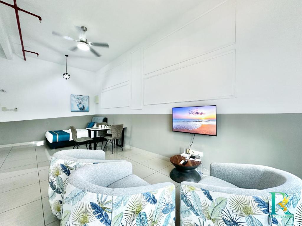 a living room with chairs and a tv on the wall at Manhattan at Austin By RR JBcity in Gua Sai