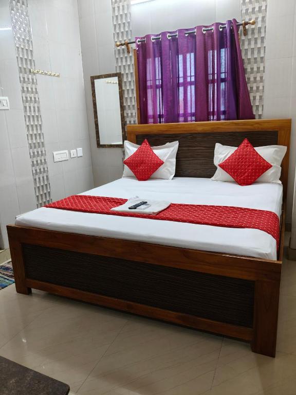 a bedroom with a bed with red pillows at SMS GRAND inn in Chennai