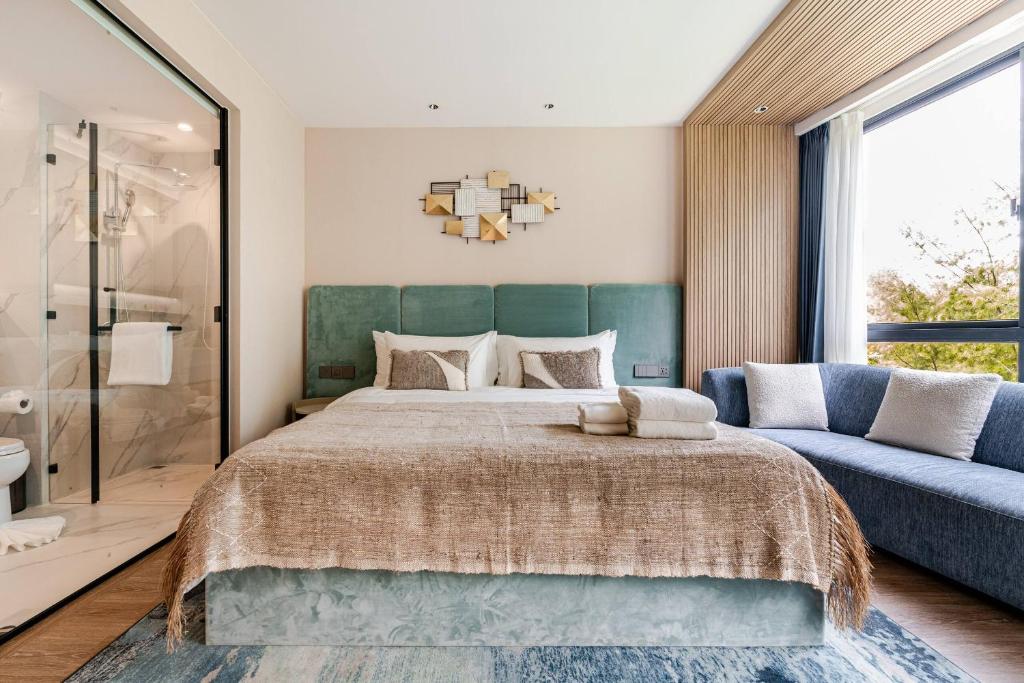a bedroom with a large bed and a couch at Laya Resort -Tropical Studio in Layan Beach
