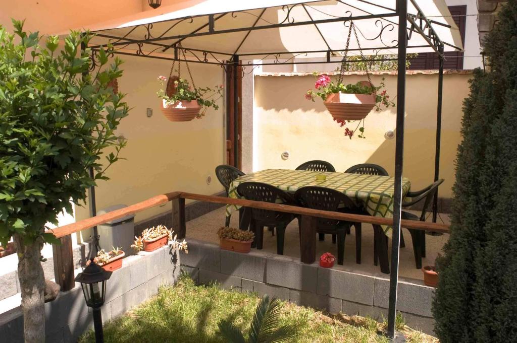 a patio with a table and chairs and potted plants at I Colori Del Sole in Fiumefreddo di Sicilia