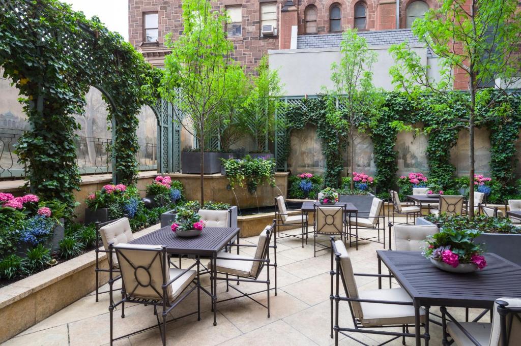 a patio with tables and chairs and plants at The Rittenhouse Hotel in Philadelphia