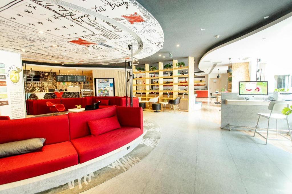 a living room with a red couch in a store at Ibis Xinzhou Qiyi RD in Xinzhou Zhan