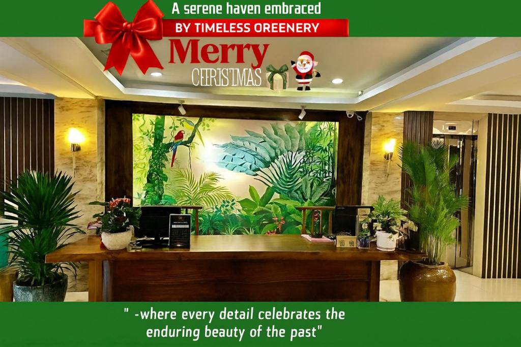 a merry christmas sign in a lobby with plants at Happy Life Green Hotel in Ho Chi Minh City