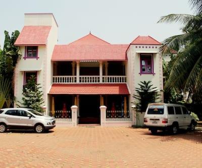 a house with two cars parked in front of it at Alps Residency in Madurai