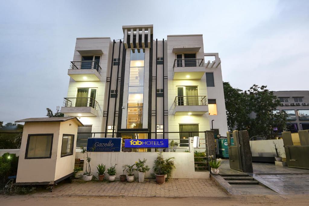 古尔冈Hotel Springbok的一座白色的大楼，前面有一块招牌