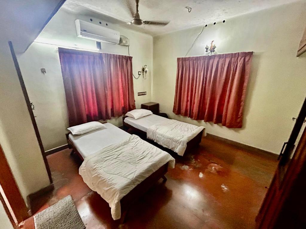 ein Krankenzimmer mit zwei Betten und einem Fenster in der Unterkunft Indeevaram in Kochi