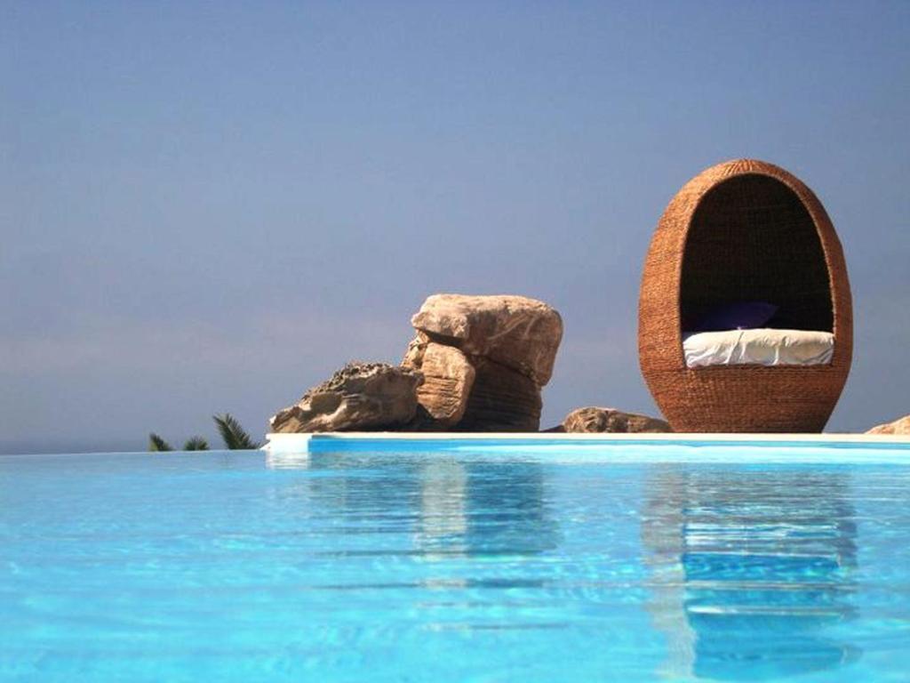 a resort swimming pool with a bed in the water at Noiva do Mar in Lourinhã