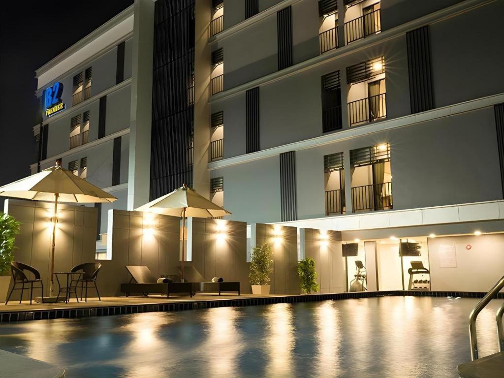 a swimming pool in front of a building at night at B2 Amata Nakorn Premier Hotel in Ban Chak Samo