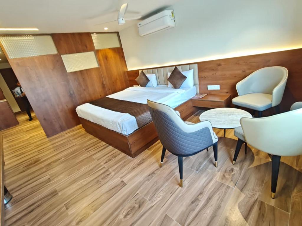 a hotel room with a bed and a table and chairs at Ricch Hotels in Hyderabad
