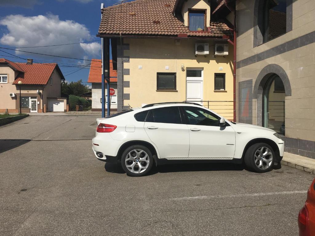 a white car parked in front of a house at Apartments Banjac in Maribor