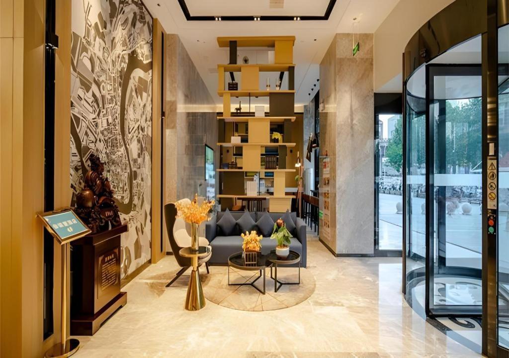 un salon avec un canapé et une table dans l'établissement Echarm Hotel Hefei West Qilitang Metro Station, à Hefei