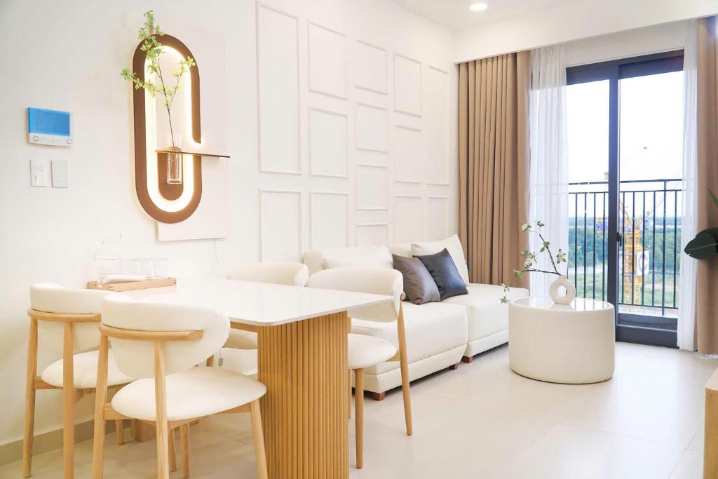 een woonkamer met een bank, een tafel en stoelen bij KNV Apartment in Thu Dau Mot